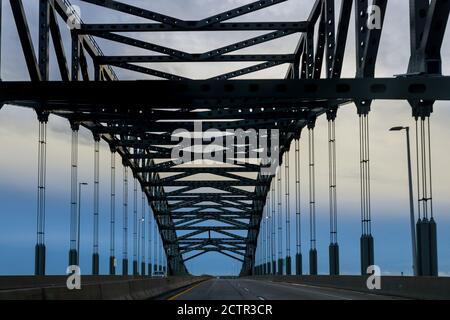 Blick auf die Metallbrücke in der Perspektive über den Fluss, gewölbte Struktur Stockfoto