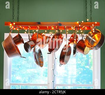 Pot Rack Leiter mit Kupfer Töpfe hängen von seinen Sprossen Dekoriert mit Weihnachtsbeleuchtung Stockfoto