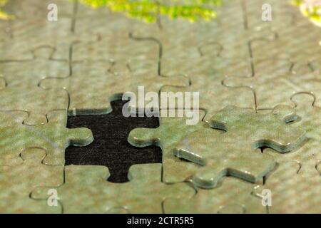 Zerlegtes Puzzle wartet auf das letzte Stück zu montieren - abgeschlossen Füllen Stockfoto