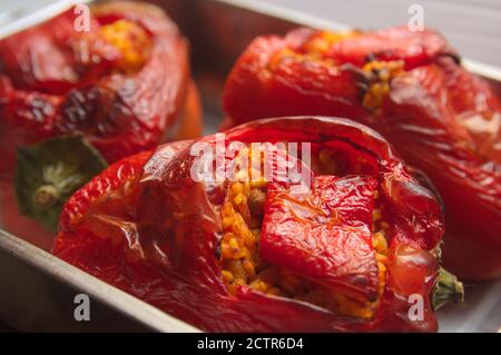 Auflauf, wo einige rote Paprika gefüllt mit Reis, Tomaten und Fleisch gebacken wurden Stockfoto