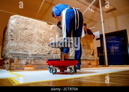 Ein Mitarbeiter, der während der Restaurierung am Sarkophag arbeitet.EIN zerbrochener römischer Sarkophag im Nationalmuseum der Altertümer in Leiden wird restauriert. Die 2.5 Meter lange Sandsteinkiste wurde 1930 bei Simpelveld in Limburg gefunden. Frühere Forschungen über das Knochenmaterial haben festgestellt, dass die eingeäscherte Frau zwischen 35 und 50 Jahre alt war, als sie starb und ein gutes Leben ohne harte Arbeit geführt hatte. Stockfoto