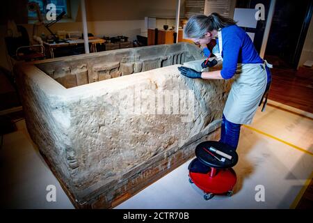 Ein Mitarbeiter, der während der Restaurierung am Sarkophag arbeitet.EIN zerbrochener römischer Sarkophag im Nationalmuseum der Altertümer in Leiden wird restauriert. Die 2.5 Meter lange Sandsteinkiste wurde 1930 bei Simpelveld in Limburg gefunden. Frühere Forschungen über das Knochenmaterial haben festgestellt, dass die eingeäscherte Frau zwischen 35 und 50 Jahre alt war, als sie starb und ein gutes Leben ohne harte Arbeit geführt hatte. Stockfoto