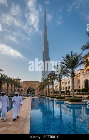 Ein paar Emirates zu Fuß mit dem Burj Khalifa im Hintergrund in Dubai, Vereinigte Arabische Emirate (VAE) Stockfoto