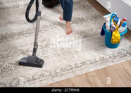 Frau putzt den Teppich mit Staubsauger im Wohnzimmer Stockfoto