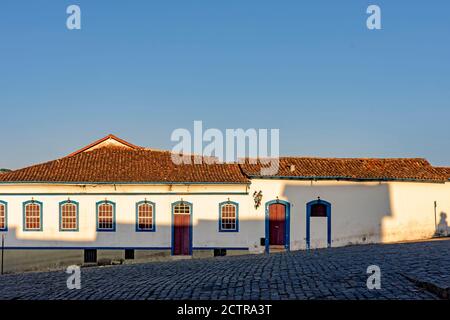 Fassade des alten Hauses im Kolonialstil Architektur in der Stadt Ouro Preto, Minas Gerais mit blauen Fenstern und Tür und den Himmel im Hintergrund