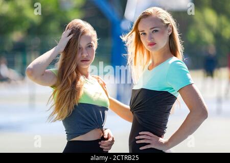 Fit Frau und Mädchen stehen in Sportbekleidung auf dem Sport Boden an sonnigen Tag Stockfoto