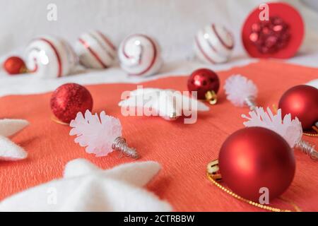 Weihnachtliche Gestaltung. Blick auf Weihnachtsdekorationen, vor rotem Hintergrund. Sterne, Unebenheiten und Bälle. Stockfoto