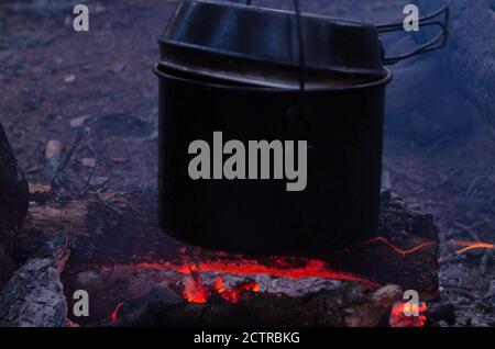 Feuer brennt in der Kampagne. Kanne Tee am Feuer Stockfoto