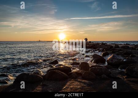 Farbenfroher Sonnenuntergang mit goldenen Sonnenstrahlen auf dem Meer. Blick auf den Pier und die Bucht. Stockfoto