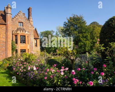 Chenies Herrenhaus und Garten im September.Bunte Dahlien, krautigen Pflanzengrenzen, Rasen.Dahlia 'Sandra', Dahlia Karma Prospero. Stockfoto