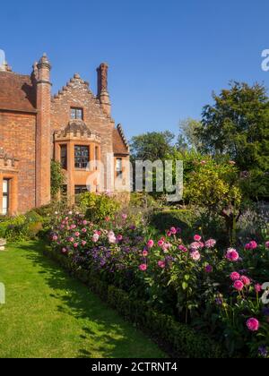 Chenies Herrenhaus und Garten an einem sonnigen Septembernachmittag.Bunte Dahlien, krautige Pflanzengrenzen, Rasen.Dahlia 'Sandra', Dahlia Karma Prospero Stockfoto