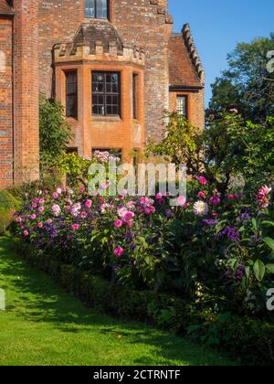 Chenies Herrenhaus und Garten an einem sonnigen Septembernachmittag.Bunte Dahlien, krautige Pflanzengrenzen, Rasen.Dahlia 'Sandra', Dahlia Karma Prospero Stockfoto