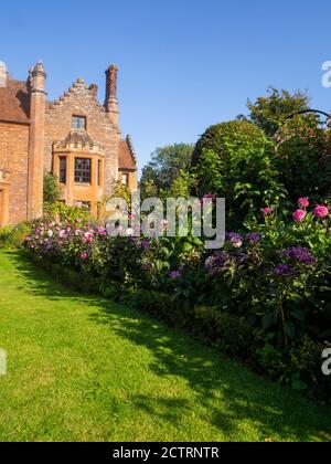 Chenies Herrenhaus und Garten an einem sonnigen Septembernachmittag.Bunte Dahlien, krautige Pflanzengrenzen, Rasen.Dahlia 'Sandra', Dahlia Karma Prospero Stockfoto
