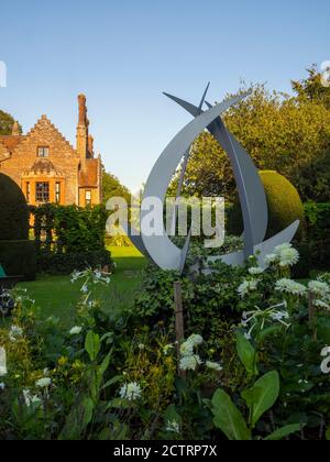 Chenies Herrenhaus und Garten Mitte September 2020. Im Sonnenlicht aus dem weißen Garten gesehen. Blauer Himmel und weiße geschwungene Skulptur. Stockfoto