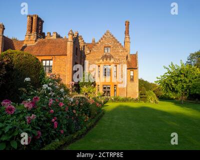 Chenies Herrenhaus und Garten an einem sonnigen Septembernachmittag, 2020. Bunte Dahlien, krautige Pflanzengrenzen, Rasen. Stockfoto