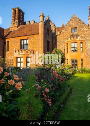 Chenies Herrenhaus und Garten an einem sonnigen Septembernachmittag, 2020. Bunte Dahlien, krautige Pflanzengrenzen, Rasen. Stockfoto
