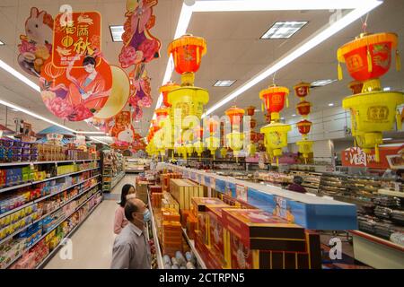 Toronto, Kanada. September 2020. Kunden, die Gesichtsmasken tragen, schauen sich vor dem Mid-Autumn Festival in einem chinesischen Supermarkt in Toronto, Kanada, am 24. September 2020 Mondkuchen an. Das chinesische Mid-Autumn Festival fällt am 1. Oktober dieses Jahres. Quelle: Zou Zheng/Xinhua/Alamy Live News Stockfoto