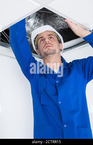 Elektriker, der Kabel in Decken einführt Stockfoto