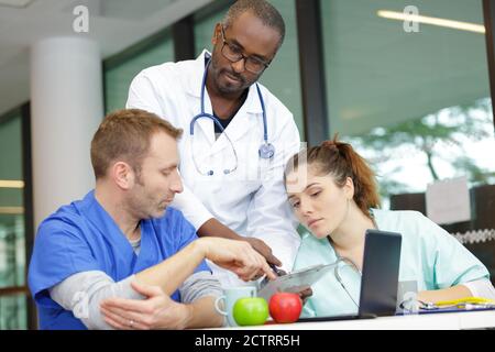 Ärzte und Krankenpfleger, die digitale Tablets betrachten Stockfoto