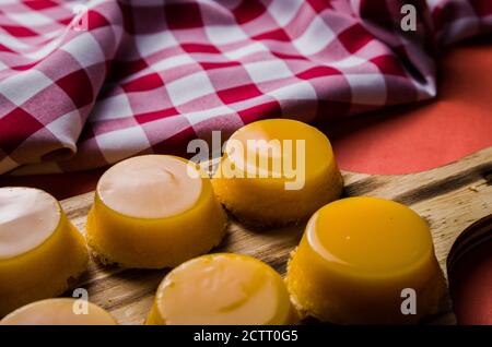 Leckere Quindins auf Holzbrett, traditionelles brasilianisches Dessert mit Eigelb, Zucker und Kokosnuss. Stockfoto