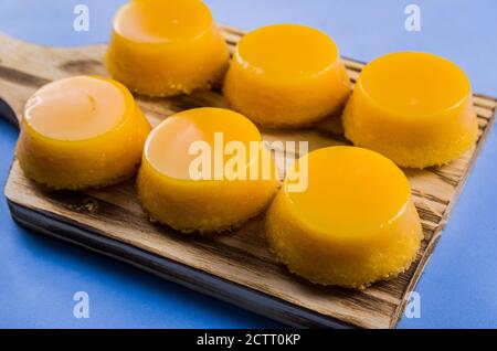 Leckere Quindins auf Holzbrett, traditionelles brasilianisches Dessert mit Eigelb, Zucker und Kokosnuss. Stockfoto