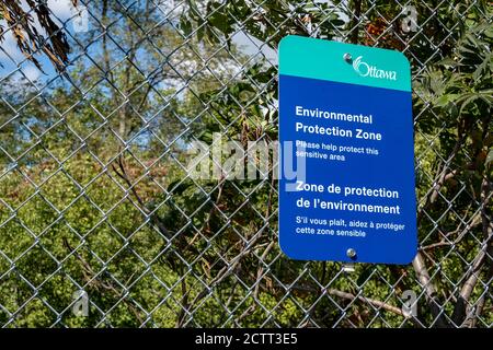 Ein Schild der Stadt Ottawa auf einem Kettengliederzaun informiert die Besucher des Carlington Park darüber, dass das Gebiet eine Umweltschutzzone ist. Stockfoto