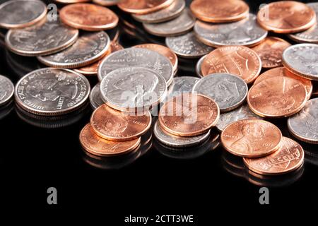 Hintergrund der 4 häufigsten amerikanischen Münzen. Pennies, Dimes, Nickels, Quarters auf schwarzem Hintergrund Stockfoto