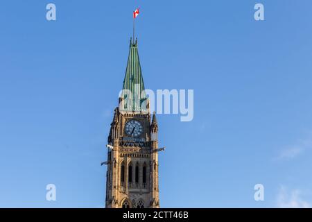 Der Peace Tower, der in der Mitte des Centre Blocks auf dem Parlament Hill in Ottawa steht, ist von unten an einem blauen Himmel zu sehen. Stockfoto