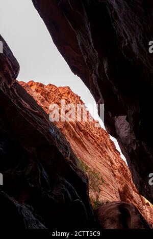 Bild der Khazali Schlucht, eine schmale Passage zwischen riesigen roten Sandsteinfelsen im Wadi Rum, Jordanien. Das Bild zeigt die Außenseite durch die Öffnung auf Stockfoto