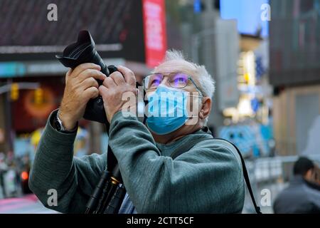 Reisen in der amerikanischen Stadt der neue normale Tourismus mit Maske Mann mittleren Alters macht ein Foto von New York USA Stockfoto
