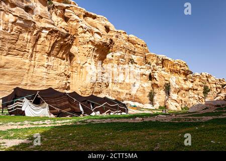 Ein beduinenzelt aus Ziegenhaar in der Wüstenlandschaft Jordaniens, in der Nähe von Petra. Bild zeigt die Felsformationen und Schäferhunde durch dieses Nein Stockfoto