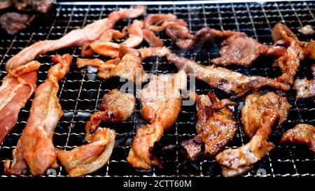 Holzkohlegrill von marinierten Schweinestreifen mit Raucheffekt Stockfoto