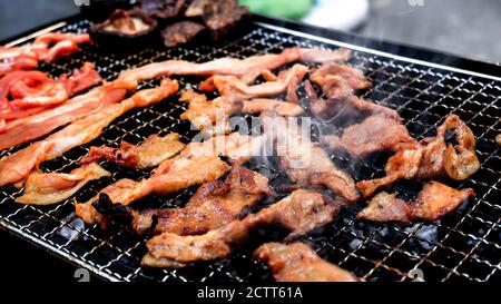 Holzkohlegrill von marinierten Schweinestreifen mit Raucheffekt Stockfoto