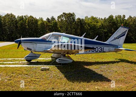 Indian Head, MD, USA 09/19/2020: Seitenansicht eines alten einmotorigen Propellerflugzeugs (Piper Cherokee PA 28), das auf dem Rasen am Flughafen Maryland geparkt ist ( Stockfoto