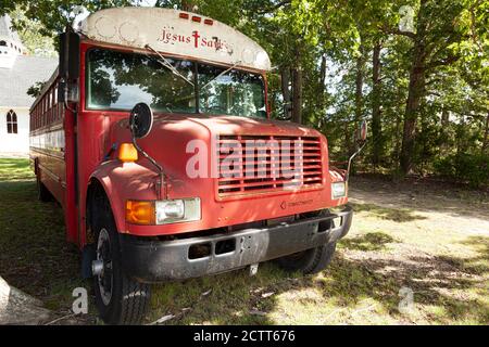 Indian Head, MD, USA, 09/19/2020: Ein roter alter rostiger IC-Schulbus, der jetzt als Kirchenbus in der Cavalary Road Baptist Church benutzt wird. Das Fahrzeug ist abgestellt Stockfoto