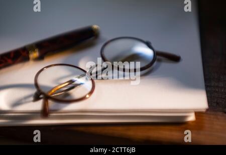 Retro Brillen und Stift auf Papierstapel Stockfoto