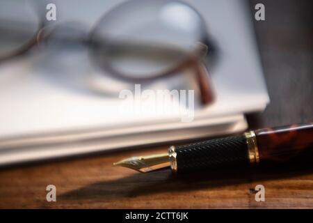 Retro Brillen und Stift auf Papierstapel Stockfoto