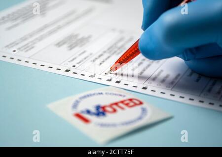 Abzeichen und handfüllendes Abstimmungsformular auf blauem Hintergrund Stockfoto