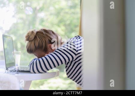 Frau mit Laptop und Einschlafen Stockfoto