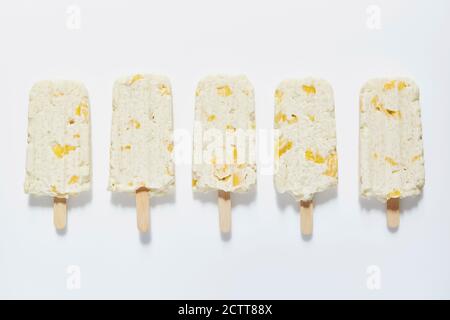 Reis- und Mango-Popsicle-Sticks auf weißem Hintergrund Stockfoto