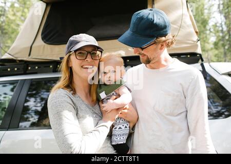 Portrait der Eltern mit Baby-Sohn (6-11 Monate) auf Camping im Wald, Wasatch Cache National Forest Stockfoto