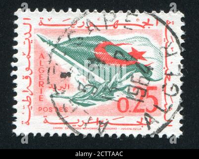 Algerien CIRCA 1963: Briefmarke gedruckt von Algerien, zeigt Flagge, Gewehr, Olivenzweig, ca. 1963 Stockfoto