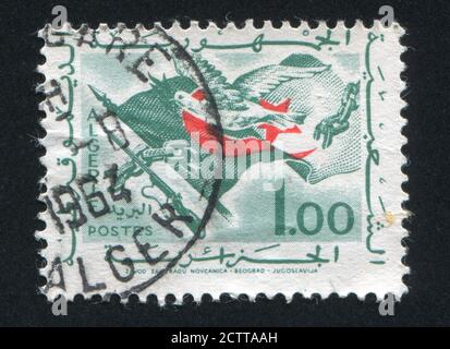 Algerien CIRCA 1963: Briefmarke gedruckt von Algerien, zeigt Flagge, Gewehr, Olivenzweig, ca. 1963 Stockfoto