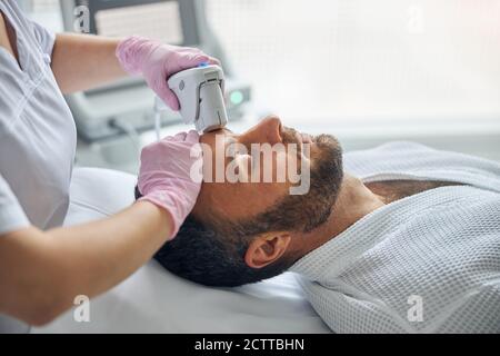 Arzt Kosmetologe Behandlung der männlichen Haut mit Laser-Gerät Stockfoto