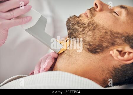 Gut aussehende junge Mann unterziehen Laser-Haarentfernung Verfahren Stockfoto