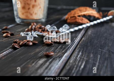 Kaffeebohnen für die Zubereitung von Iced Thai Kaffee mit Kokosmilch und zerstoßenem Eis in einem hohen Glas. Stockfoto