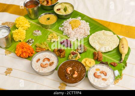 Onam sadhya, indische Frauen essen mit Hand gekochten Reis, serviert für Kerala Indian Festival mit Curries Sambar, Avial, Thoran, Papadum, Payasam, Banana Stockfoto