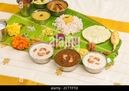 Onam sadhya, indische Frauen essen mit Hand gekochten Reis, serviert für Kerala Indian Festival mit Curries Sambar, Avial, Thoran, Papadum, Payasam, Banana Stockfoto