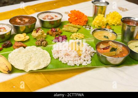 Onam sadhya, indische Frauen essen mit Hand gekochten Reis, serviert für Kerala Indian Festival mit Curries Sambar, Avial, Thoran, Papadum, Payasam, Banana Stockfoto