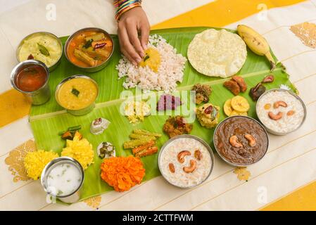 Onam sadhya, indische Frauen essen mit Hand gekochten Reis, serviert für Kerala Indian Festival mit Curries Sambar, Avial, Thoran, Papadum, Payasam, Banana Stockfoto